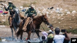 19 Eylül 2021 - ABD-Meksika sınırında, Del Rio'da bir köprü altında, ABD'ye sığınma umuduyla bekleyen Haitili göçmenlere sınır güvenlik güçleri at üzerinde müdahale etti